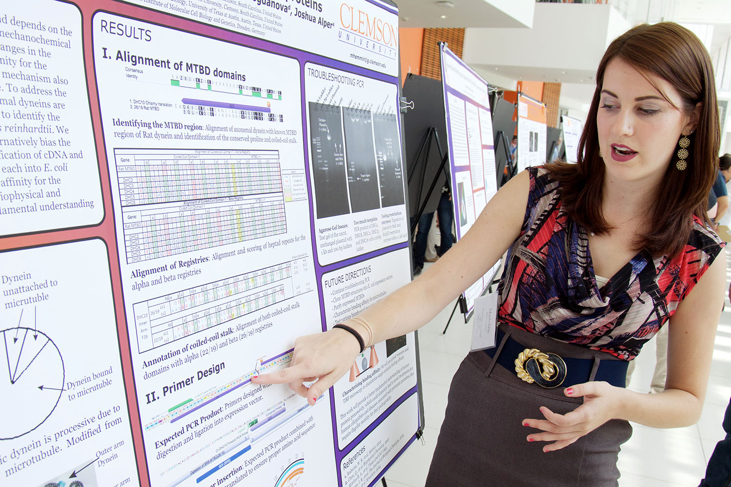 Woman pointing to poster with scientific data