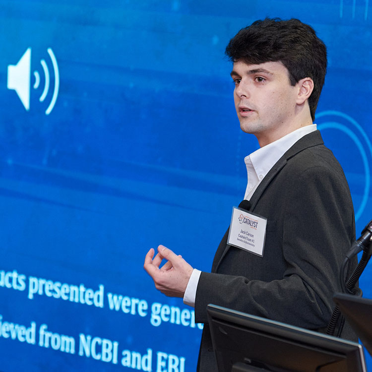 Man presenting in front of video wall.