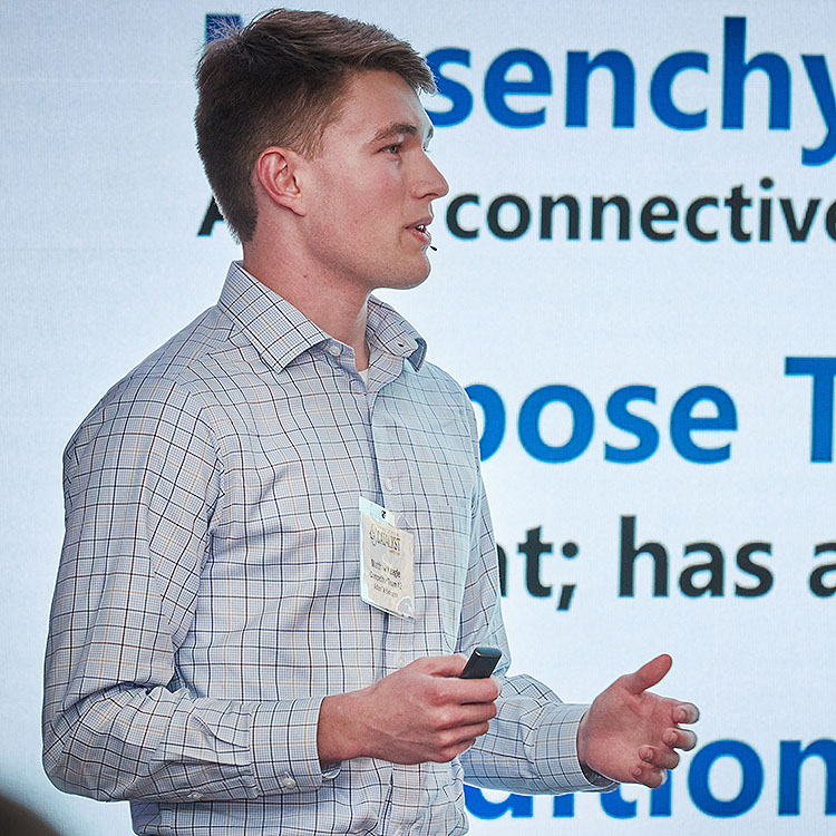 Man presenting in front of video wall.