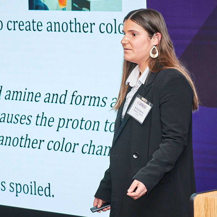 Girl giving presentation in front of display wall.