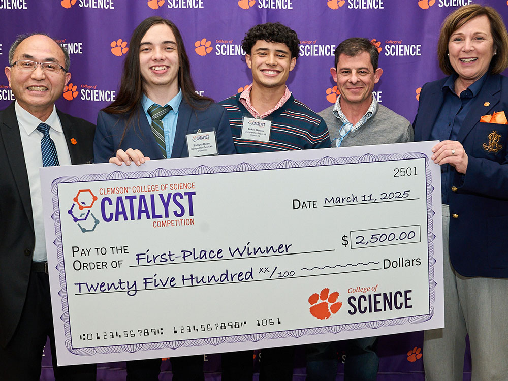Five people in front of a College of Science purple step-and-repeat wall, holding Catalyst first-place-winner check for $2,500.