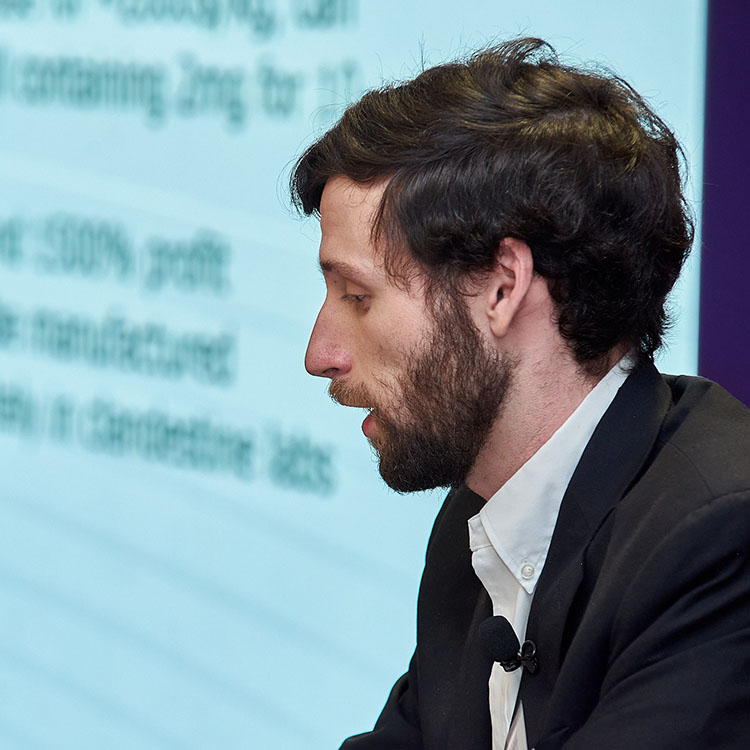 Man presenting in front of video wall.