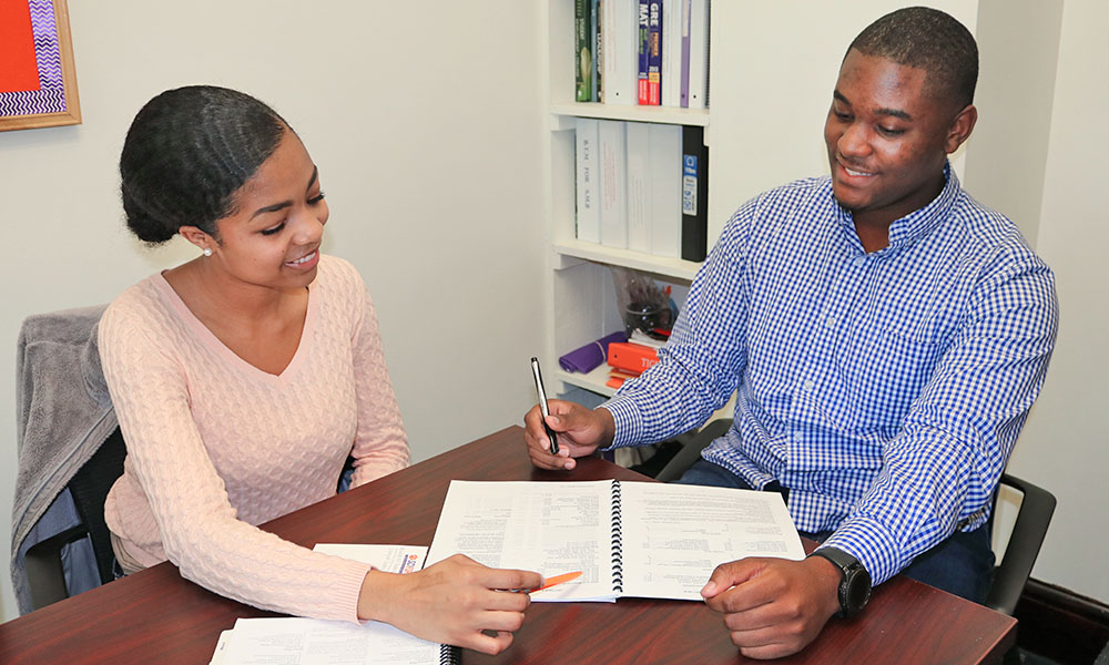 Student mentoring another student with workbook