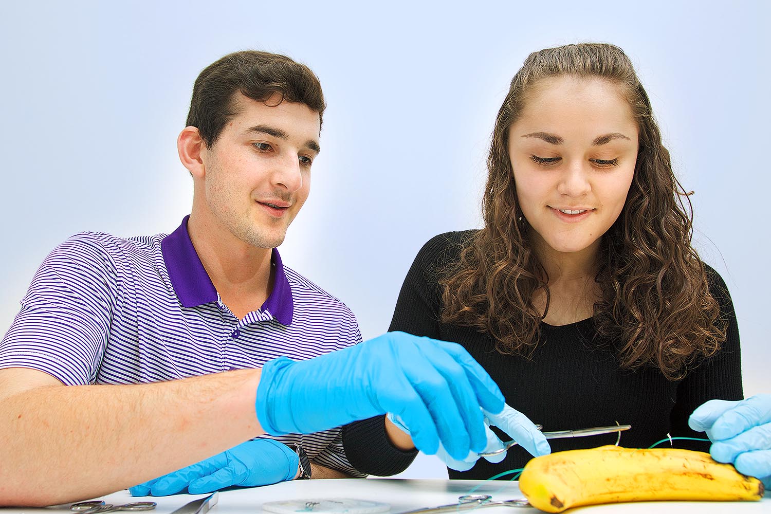 Students practicing stitches on a bananna