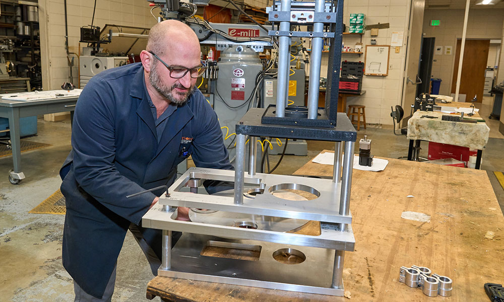 Man wearing goggles working in a machine shop.