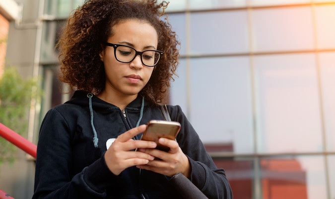 student looking at smartphone