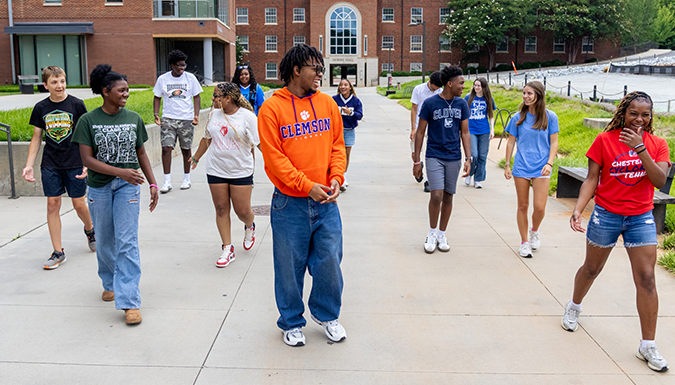Clemson students walking and chatting on campus.