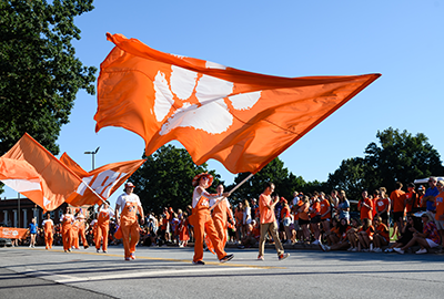 Clemson students waving Clemson flags in the First Friday Parade