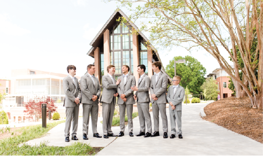 Groom laughing with goomsmen outside of the Samuel J. Cadden Chapel.