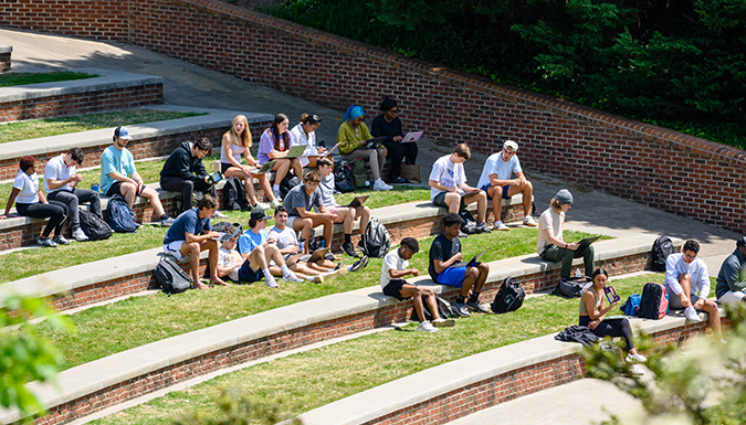 Students Sitting In Outdoor Amphiteater Studying