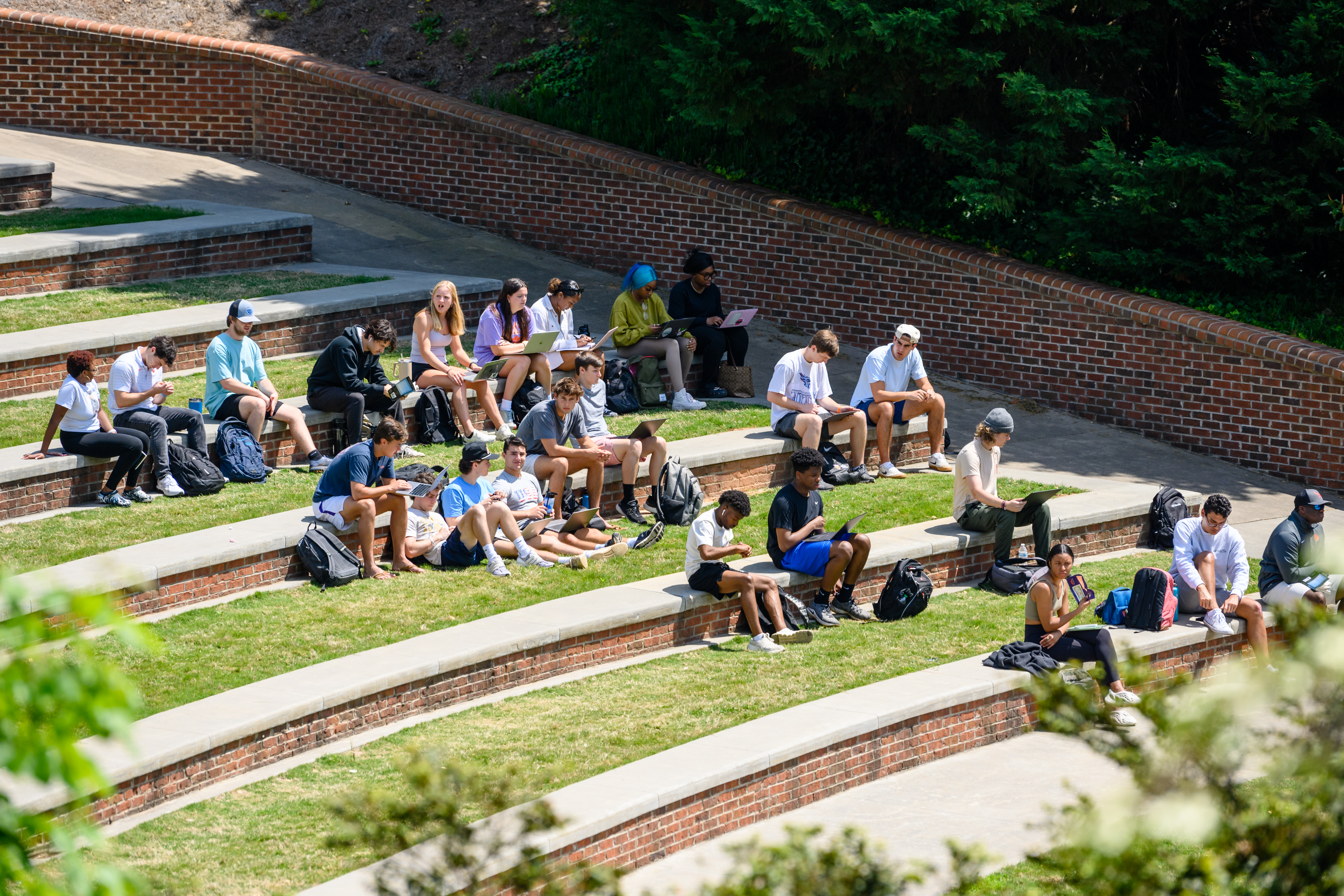 Students Sitting In Outdoor Amphiteater Studying