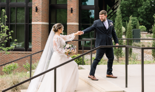 Husband and wife laughing in the garden after their wedding ceremony.