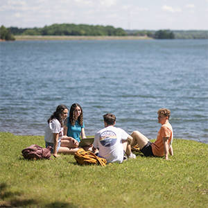 Students sit outside by Lake Hartwell studying and socializing together