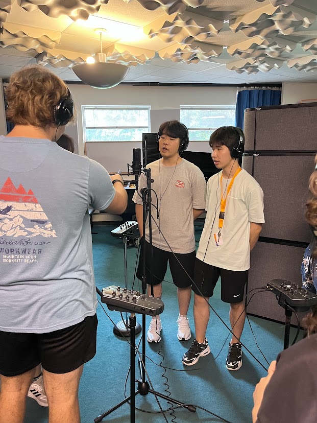 Students recording a song in the music booth
