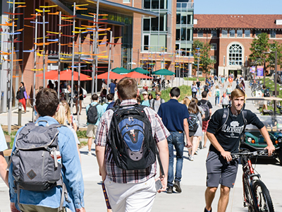 Many students walking outside CORE Campus on a sunny day