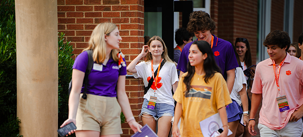 Group of students walking together on campus, engaging with one another during a campus event.