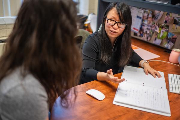 A faculty member having a conversation with a student in an office.