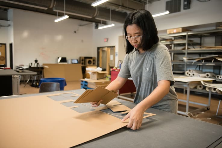 A packaging science students works to develop a prototype.