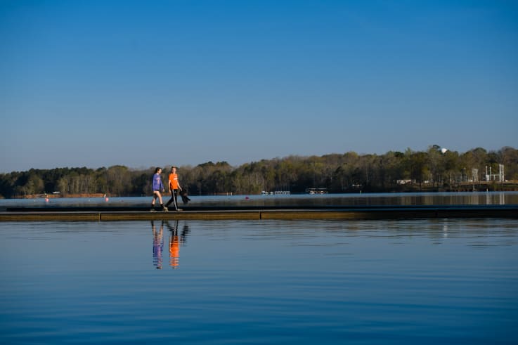 Two students walk along a dock on lake hartwell