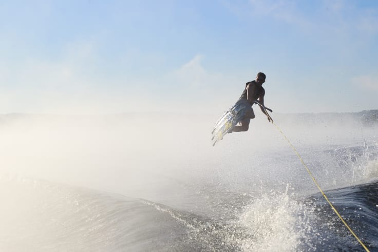 A watersports club member jumps a wake on a wakeboard on lake hartwell.