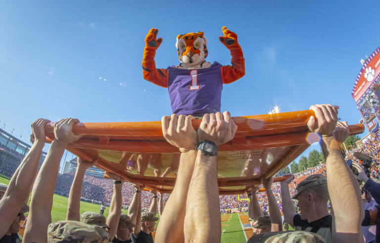 The tiger mascot poses while being held aloft by Clemson ROTC members